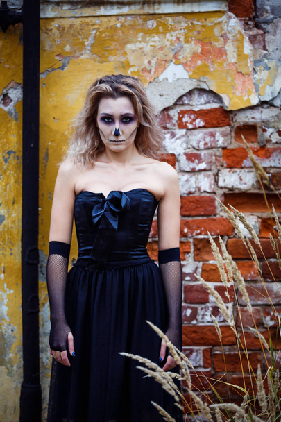 blonde Woman in a sexy black dress destroyed house contemplating devastation. halloween make up - Photo, Image