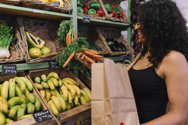 женщина покупает морковь в супермаркете
 - Фото, изображение