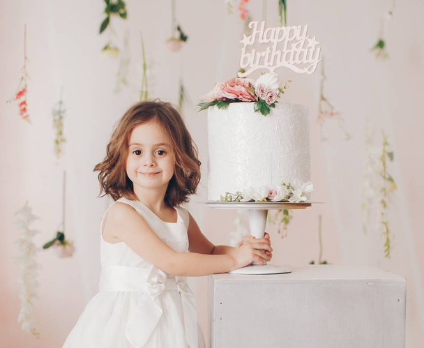 Cute little girl in dress with cake at home, happy childhood concept  - Fotoğraf, Görsel