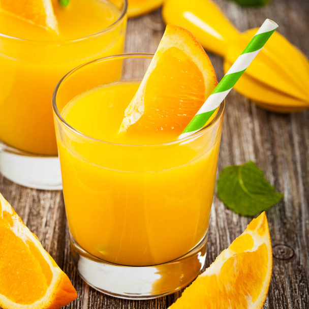 Апельсиновый сок на деревянном фоне. Селективный фокус
. - Фото, изображение