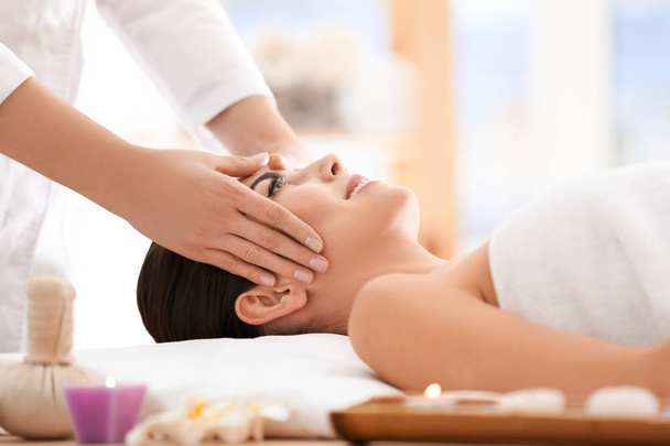 Mulher jovem desfrutando de massagem facial no salão de spa
 - Foto, Imagem