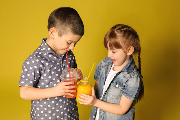 Carino bambini piccoli con succo di agrumi su sfondo di colore
 - Foto, immagini
