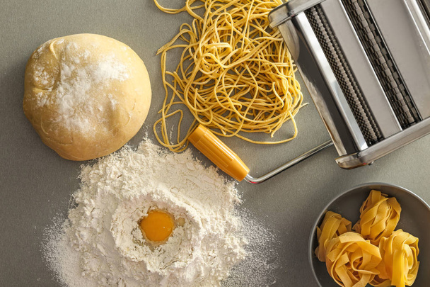 Tasainen lay koostumus metalli pasta maker ja tuotteita kevyellä taustalla
 - Valokuva, kuva