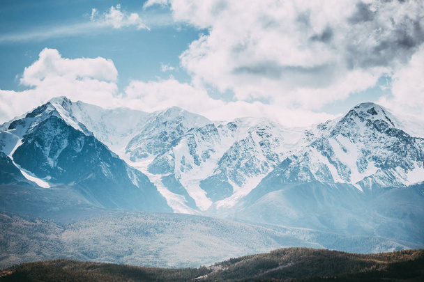 Hermosa cordillera bajo las nubes. Picos nevados de rocas. Vista del valle de la montaña en la República de Altai
. - Foto, imagen