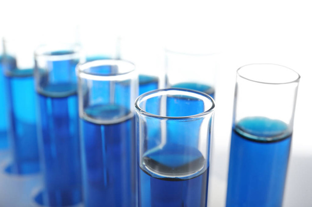 Beyaz zemin üzerinde mavi sıvı bulunan test tüpleri - Fotoğraf, Görsel