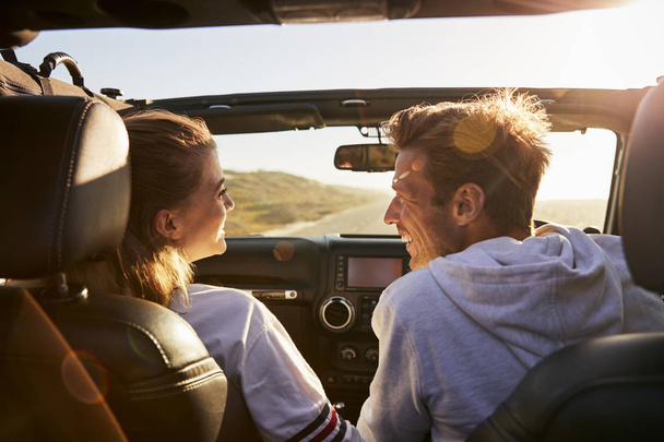Couple look at each other while driving, rear passenger POV - Photo, Image