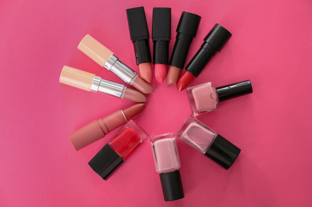 Flat lay composition with different lipsticks and nail polishes on color background. Professional cosmetic - 写真・画像
