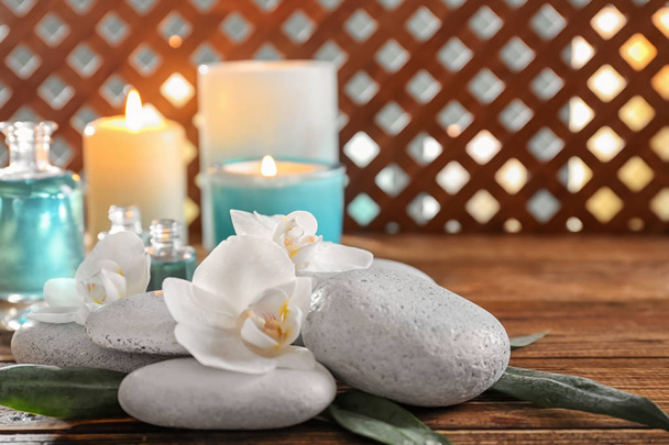 Piedras de spa con hermosas flores en mesa de madera
 - Foto, Imagen