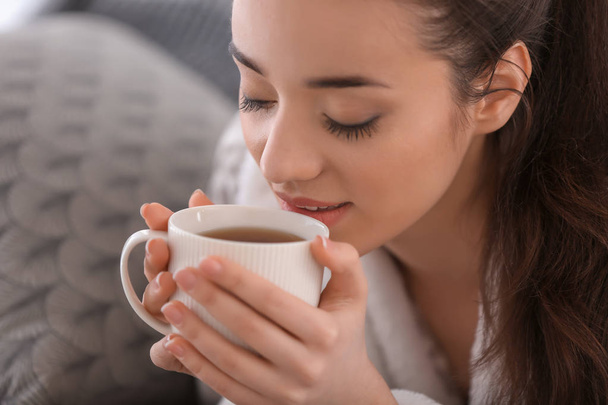schöne junge Frau mit heißem Tee zu Hause, Nahaufnahme - Foto, Bild