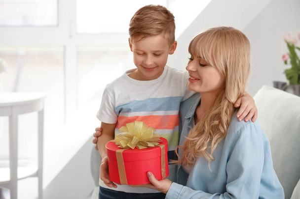 Portrait of cute little boy and his mother with gift box at home - Φωτογραφία, εικόνα