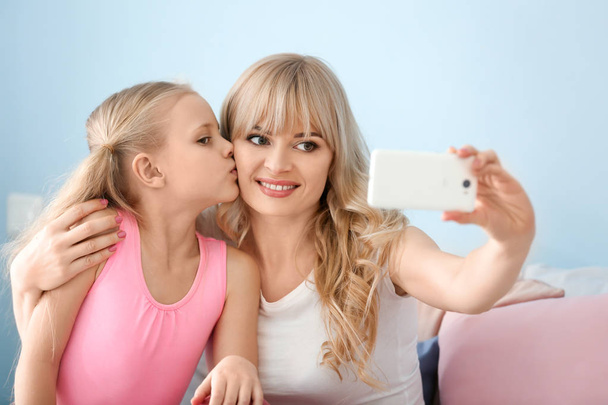 Linda niña y su madre tomando selfie en casa
 - Foto, imagen