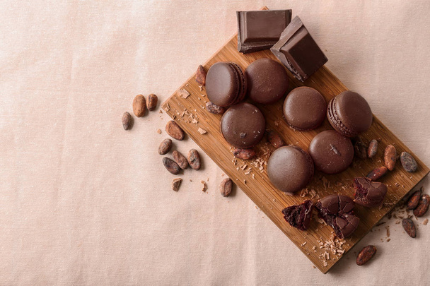 Composición con macarrones de chocolate sobre tabla de madera, vista superior
 - Foto, Imagen