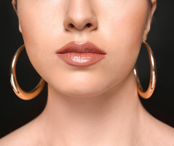 Young woman with beautiful professional makeup on black background, closeup - Zdjęcie, obraz