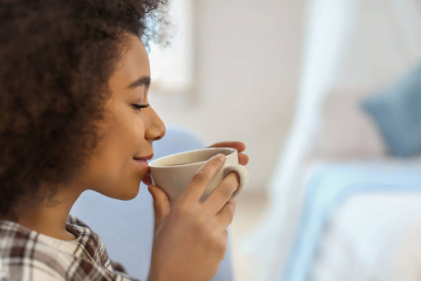 Belle femme afro-américaine buvant du thé à l'intérieur
 - Photo, image