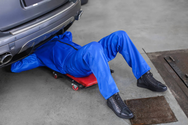 Male mechanic fixing car in service center - Foto, Imagem