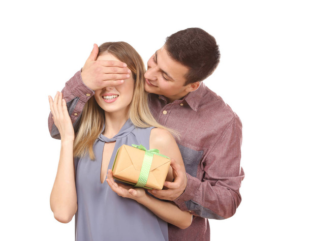 Young man giving present to his beloved girlfriend on white background - Foto, Bild