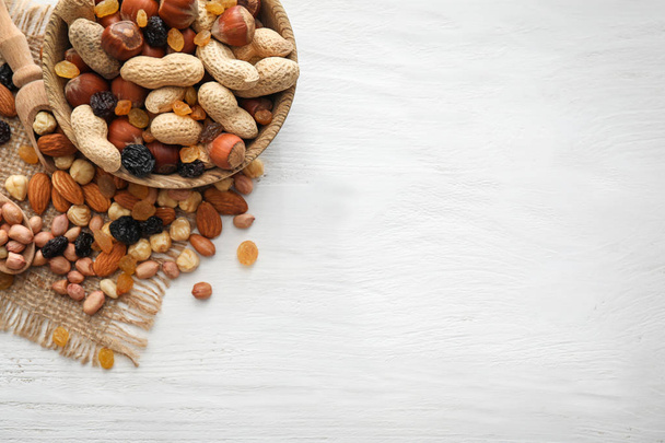 Bowl erilaisia maukkaita pähkinöitä ja kuivattuja hedelmiä puupöydällä
 - Valokuva, kuva