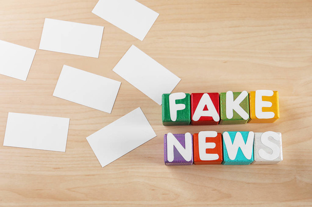 Phrase FAKE NEWS made from cubes with letters on wooden background - Fotó, kép