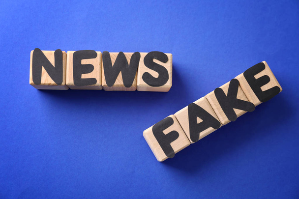 Tekst Fake Nieuws gemaakt van kubussen met letters op een gekleurde achtergrond - Foto, afbeelding