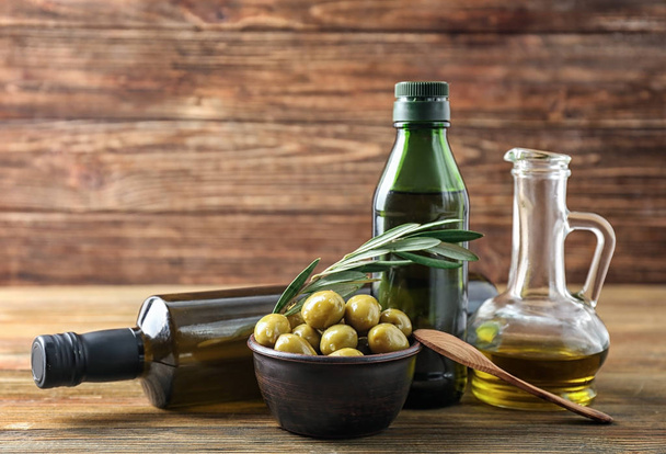 Glassware with oil and olives on wooden table - Photo, Image