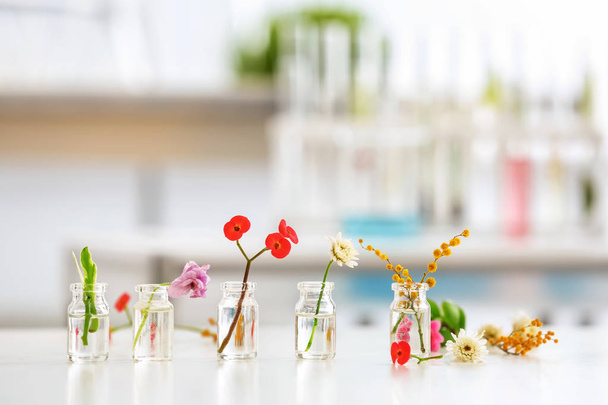 Květiny ve skleněných lahvích na stole - Fotografie, Obrázek