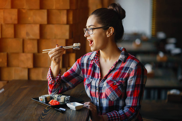 girl eating sushi at the restaurant - Foto, immagini
