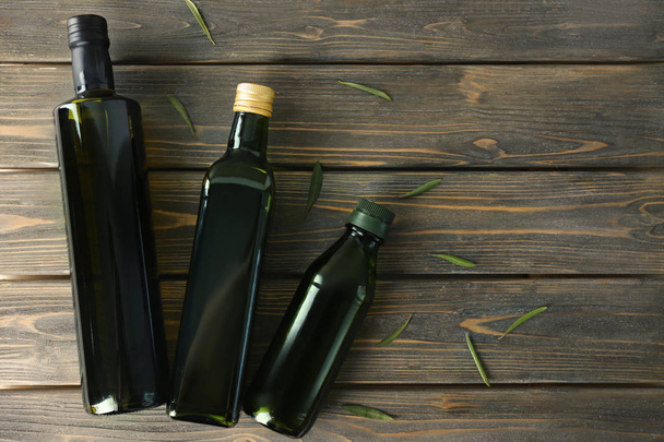 Bottiglie con olio d'oliva su fondo di legno
 - Foto, immagini