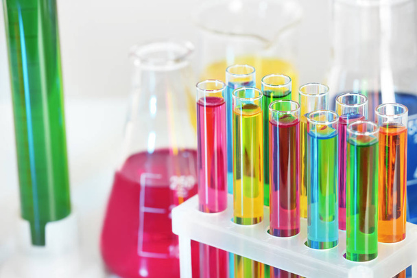 Reageerbuisjes met kleurrijke vloeistoffen in rek, close-up - Foto, afbeelding