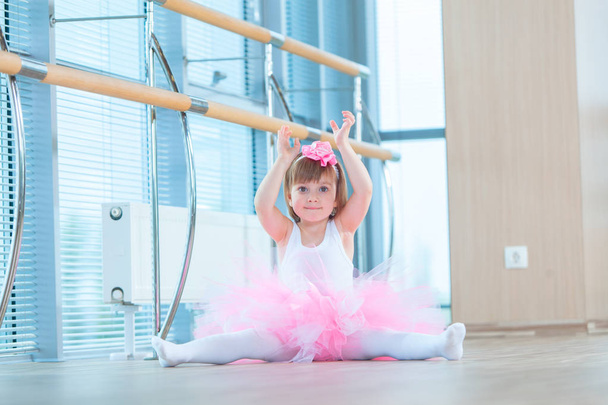 Little ballerina girl in a pink tutu. Adorable child dancing classical ballet in a white studio. Children dance. Kids performing. Young gifted dancer in a class. Preschool kid taking art lessons. - Fotoğraf, Görsel