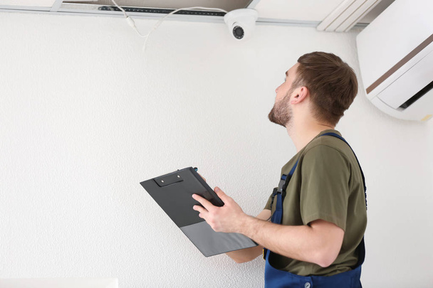 Elektricien installeren bewakingscamera binnenshuis - Foto, afbeelding
