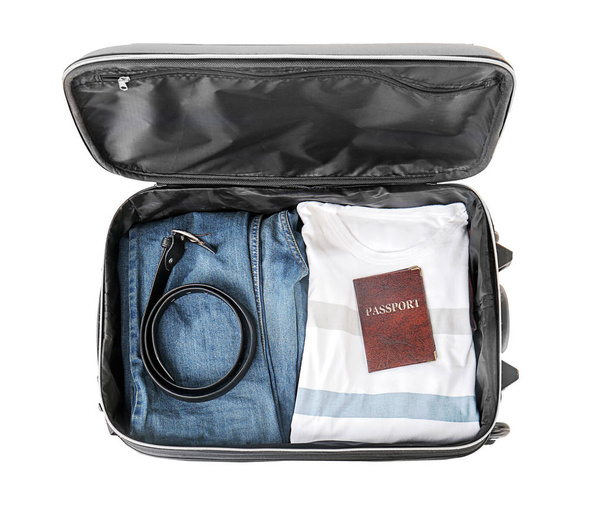 Open koffer met ingepakte dingen op witte achtergrond, bovenaanzicht - Foto, afbeelding