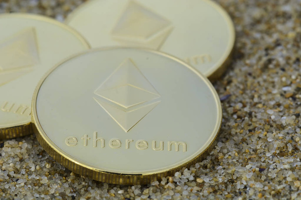 Ethereum coin  close up on the beach, golden color . - Photo, Image