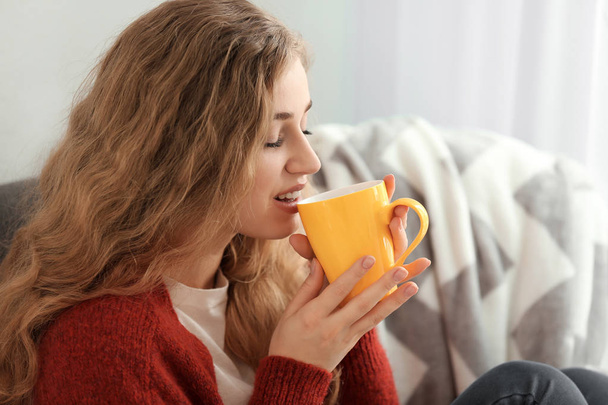 Young woman drinking tea at home - Фото, изображение