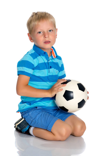 Little boy is playing with a soccer ball. - Фото, изображение