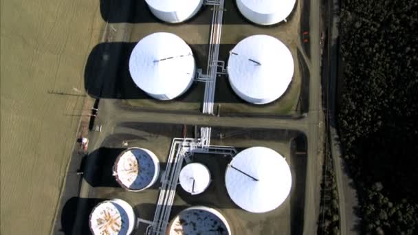 Vista aérea de tanques de refinaria de petróleo e encosta próxima
 - Filmagem, Vídeo