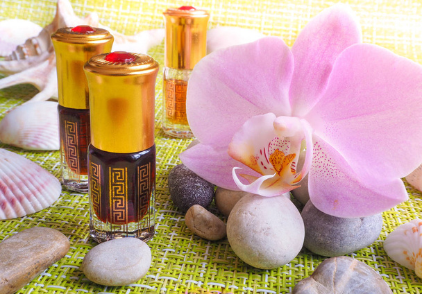 Aceite de masaje árabe. Piedras y flores de orquídea con aceite natural en el salón Spa
. - Foto, Imagen