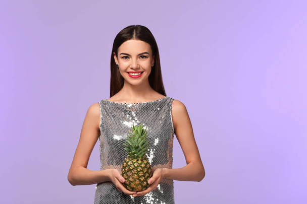 Привлекательная молодая женщина с ананасом на цветном фоне
 - Фото, изображение