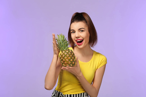 Attractive young woman with pineapple on color background - Foto, Imagem