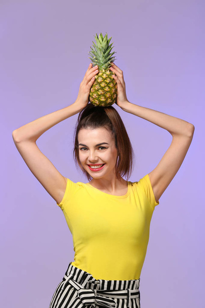 Attractive young woman with pineapple on color background - Photo, Image