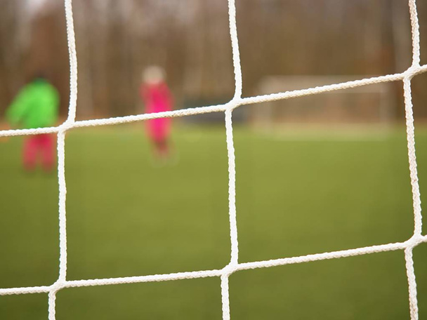 Football player stands against goal with net and stadium. Football gate net. Soccer gate - Fotó, kép
