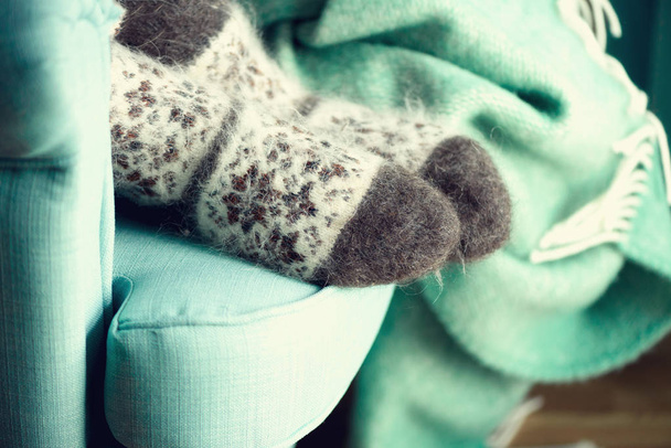 Feet in woolen socks. Cozy autumn evening. Winter and Christmas holidays concept. Copy space - Fotoğraf, Görsel