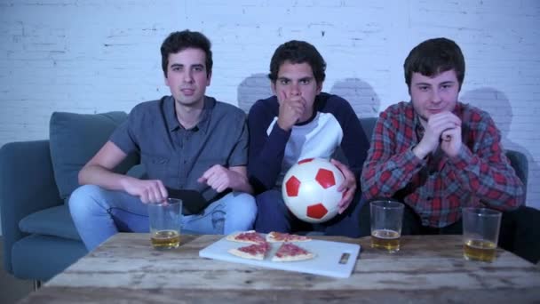 young group of caucasian football fans disappointed watching a football game on the couch. - Metraje, vídeo