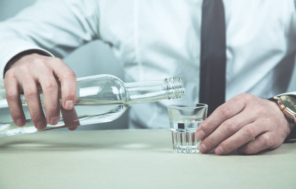 Businessman pouring vodka into a glass. - Photo, Image