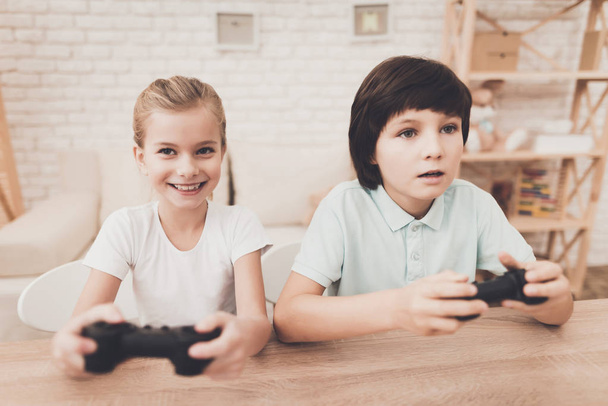 Brother and sister playing video games at home - Foto, imagen