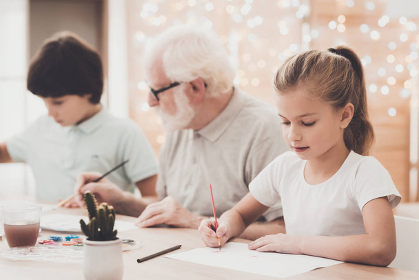 Grandfather, grandson and granddaughter drawing at home - Photo, image