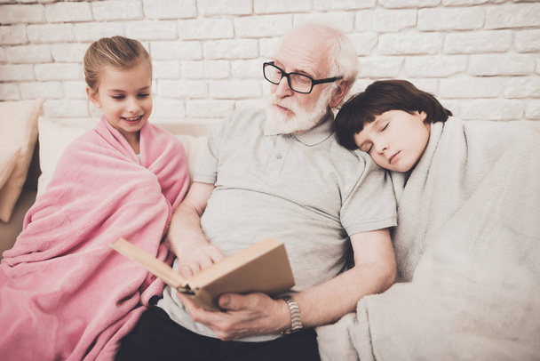 Grandpa reading book with children at home - Foto, Imagen