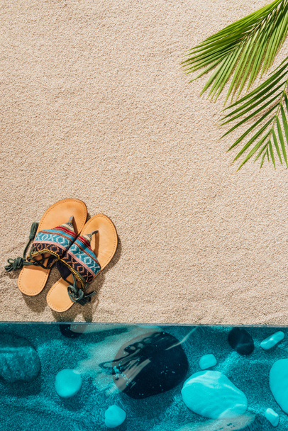 top view of stylish flip flops on sandy beach - Zdjęcie, obraz