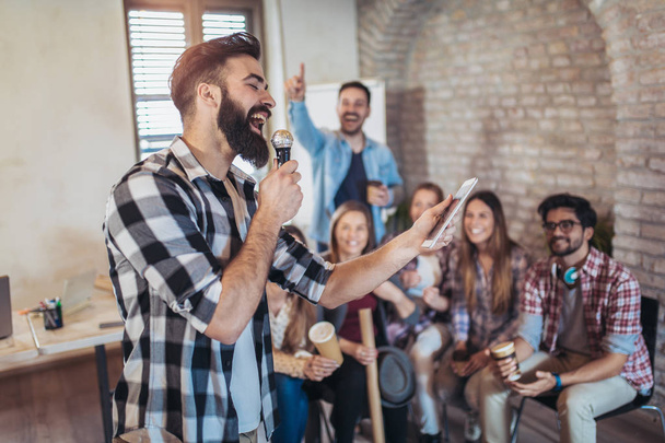 Podnikatelé týmu školení cvičení během team-buindingové seminář zpívá karaoke. - Fotografie, Obrázek