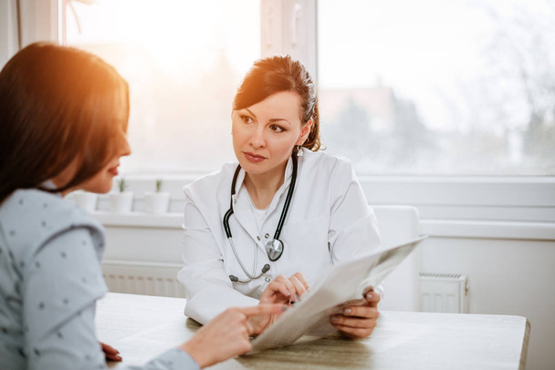 Young doctor talking with patient in office - Photo, image