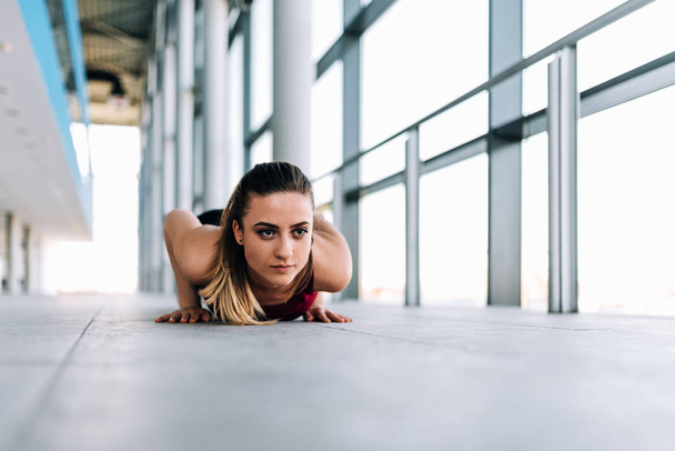 Fit woman doing push-ups indoors - Fotoğraf, Görsel